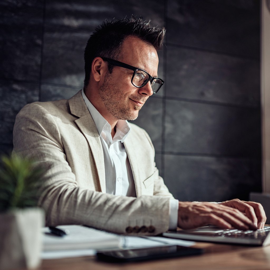 Focused businessman discussing Tharwatalwatan's tailored group health insurance plans in a corporate setting