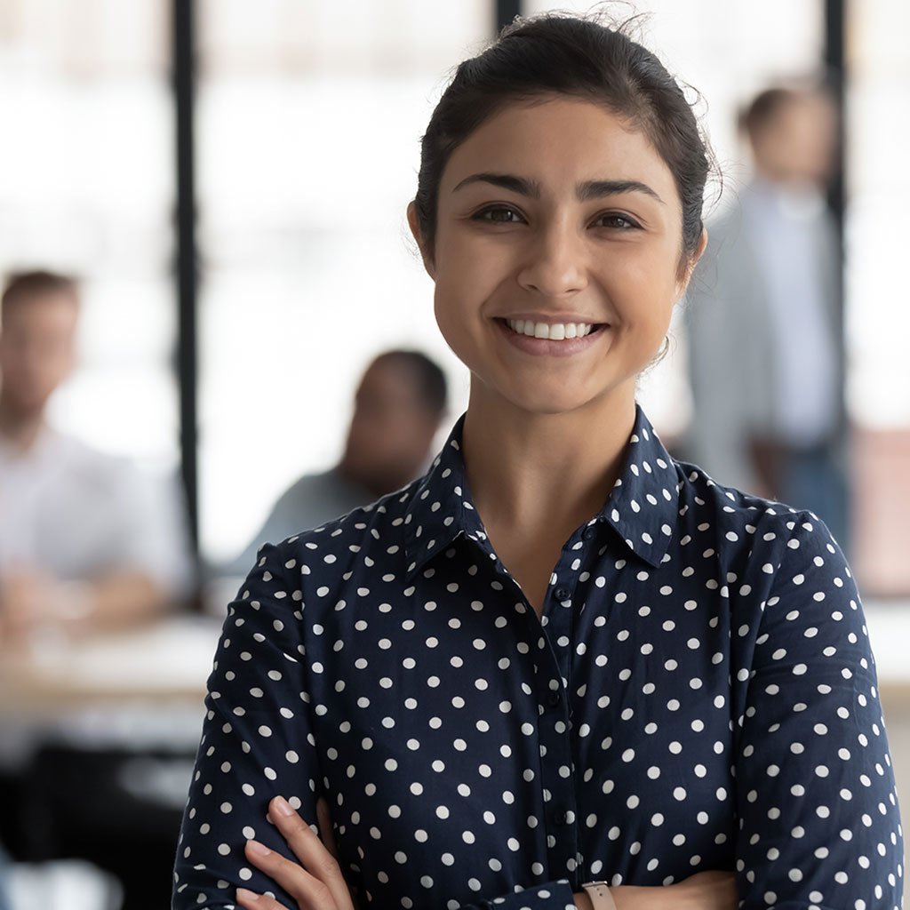 Smiling female professional representing seamless access to cashless medical insurance across the Middle East.